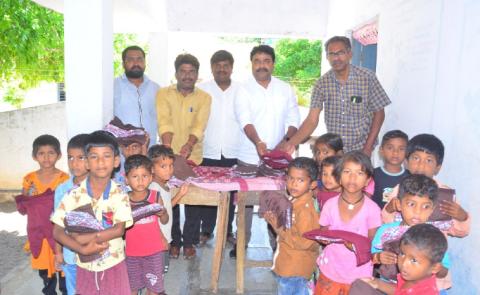 Sarpanch Sriha distributing clothes to students
